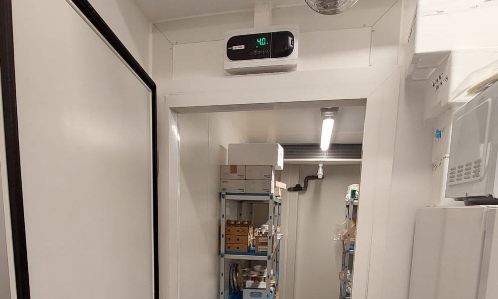 Porte de chambre froide, régulateur de température et allée d’étagères