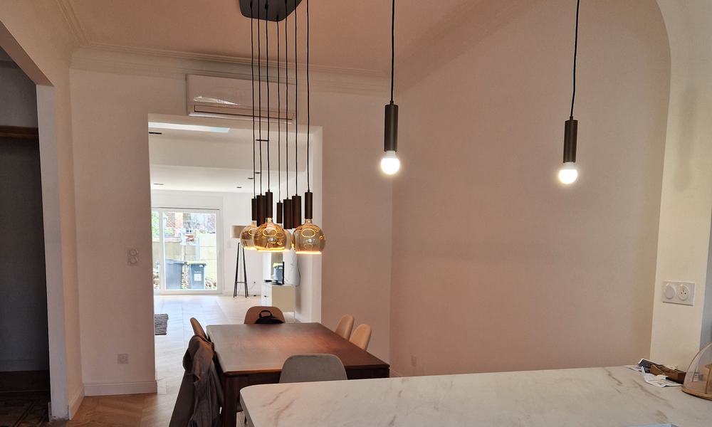 Climatiseur mural au-dessus de la salle à manger d’une maison, vue depuis la cuisine