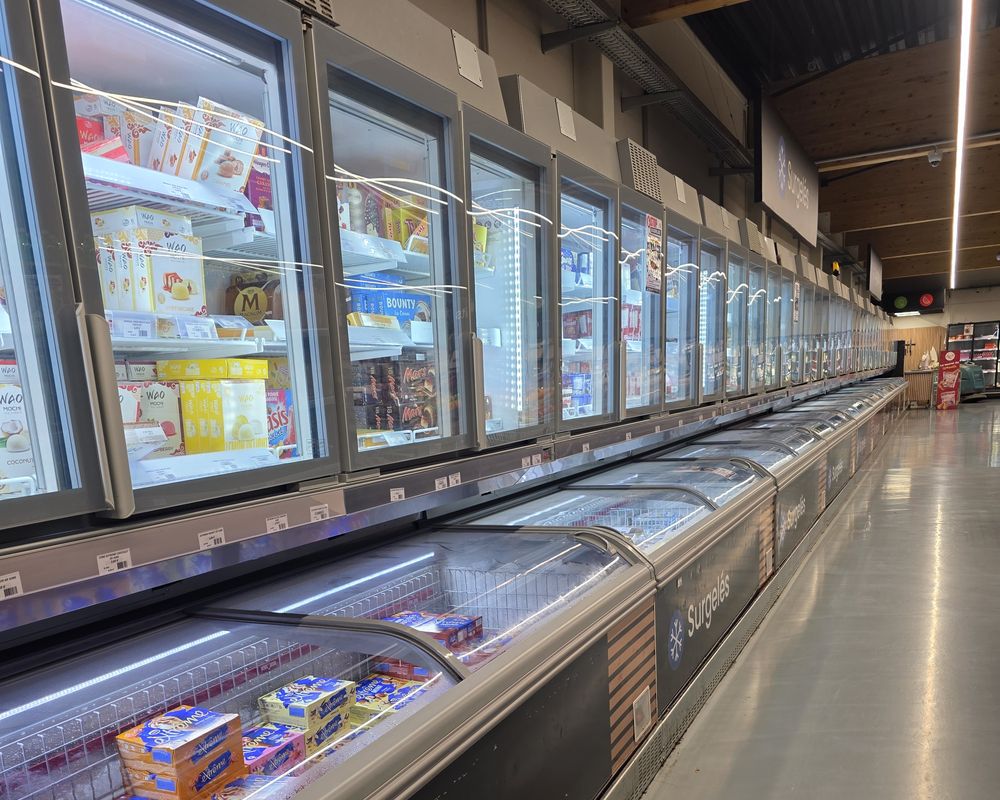 Allée de surgelés : armoires à portes vitrées et bacs de congélation dans un supermarché